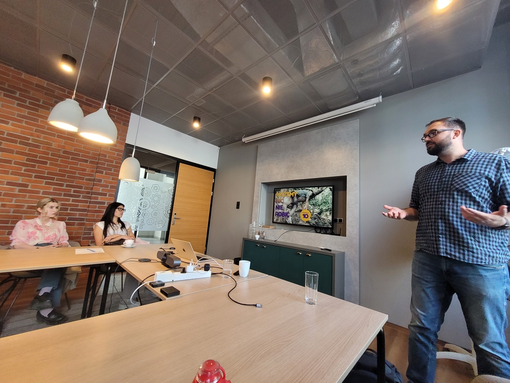 wizja lokalna studentów EkSocu w Animalhotels.com - dwie studentki oglądają przysłuchują się prezentacji pracownika firmy