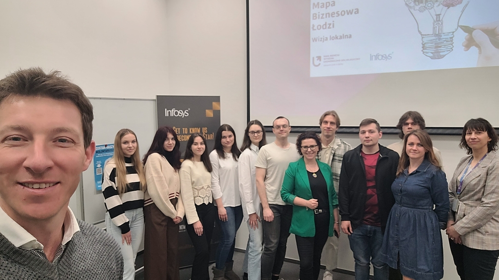Mapa Biznesowa Łodzi - Wizja Lokalna - Infosys 17.04.2024 - zdjęcie grupowe z uczestnikami wydarzenia, którzy stoją uśmiechnięci; po lewej w zbliżeniu twarz pracownika firmy, który wykonywał zdjęcie