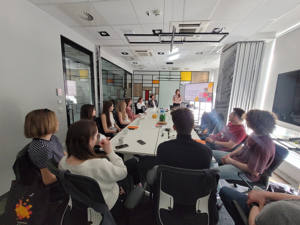 Mapa Biznesowa Łodzi - Wizja Lokalna - PwC 9.04.2024 - kilkunastu uczestników wydarzenia siedzi wokół długiego stołu i słucha prezentacji trójki pracowników firmy