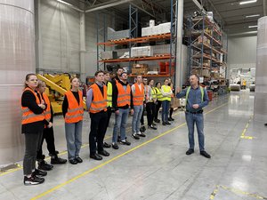 Mapa Biznesowa Łodzi - Wizja Lokalna - SWM 16.01.2023 r. - grupa studentów zwiedza halę produkcyjną pod opieką pracownika firmy